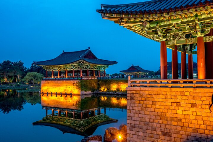 As dusk descends witness the serene reflections of ancient architecture on tranquil waters blending history and natural beauty in Gyeongju's remarkable landscapes. A perfect moment for travelers seeking cultural richness.